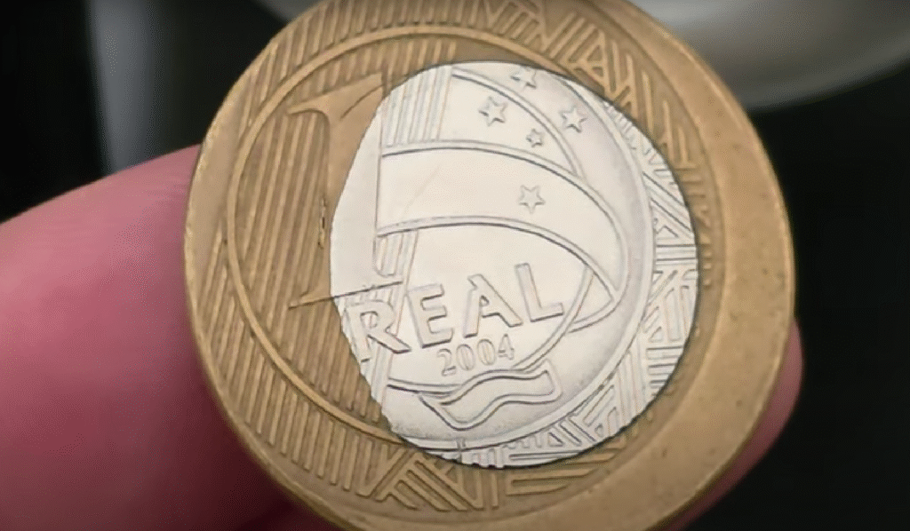 Moeda brasileira de 1 real com falha de fabricação visível.