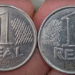 Duas moedas brasileiras de 1 real de 1994 com sinais de desgaste e marcas de uso.